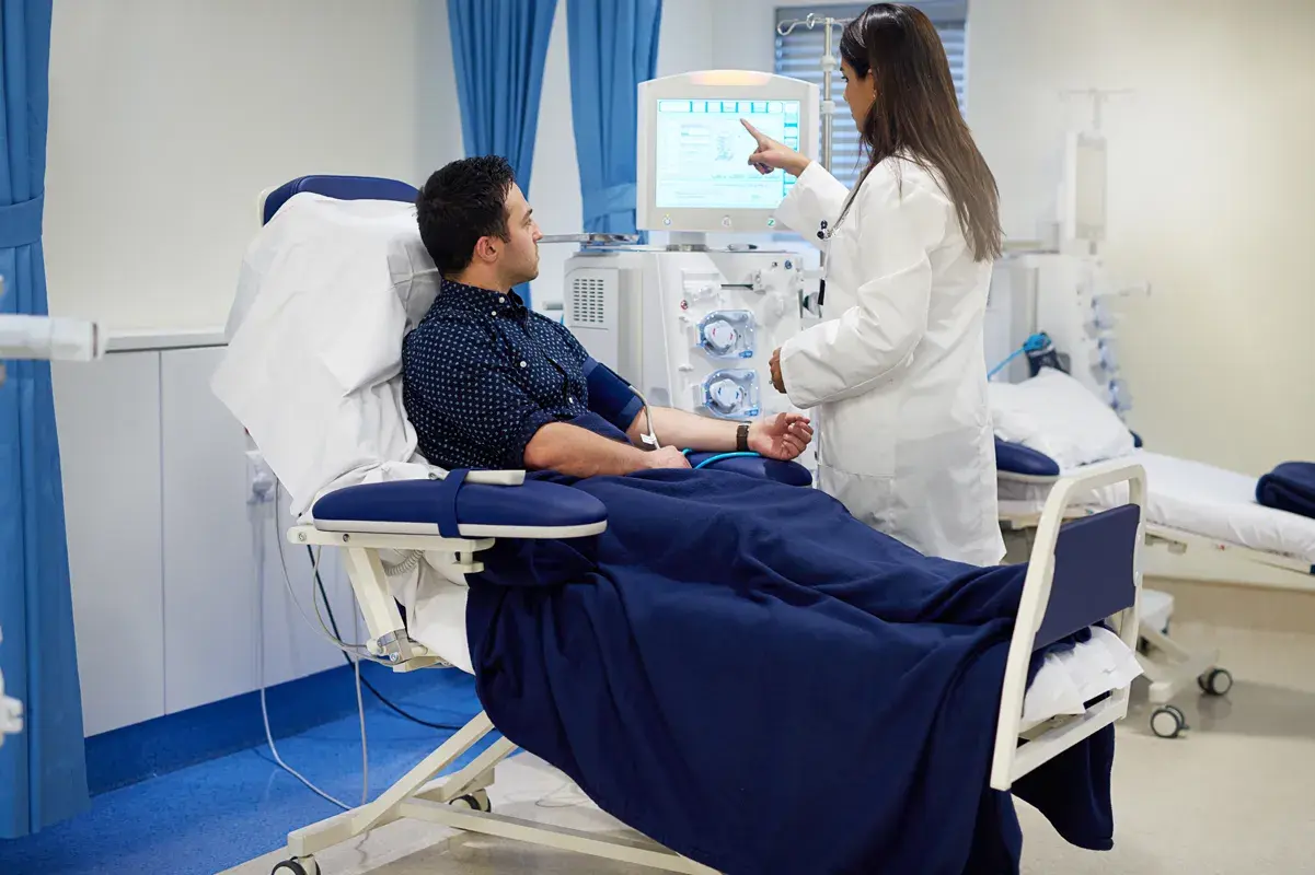 Man in dialysis machine with doctor explaining condition