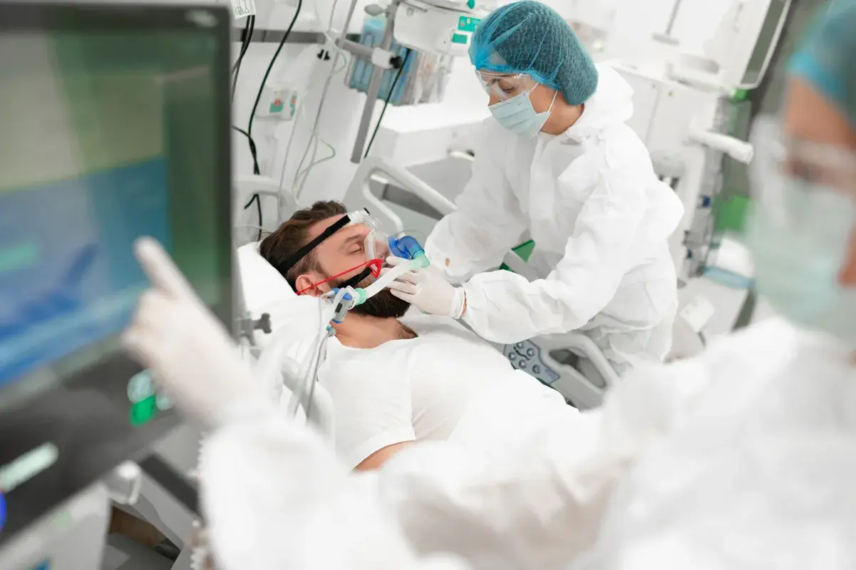 Medical team treating patient on ventilator in ICU
