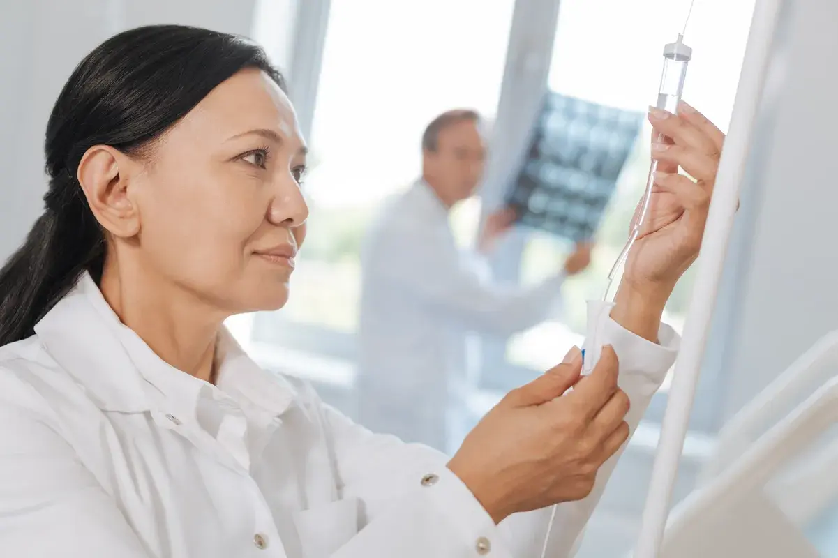 Nurse adjusting IV fluid drip for hospitalized patient