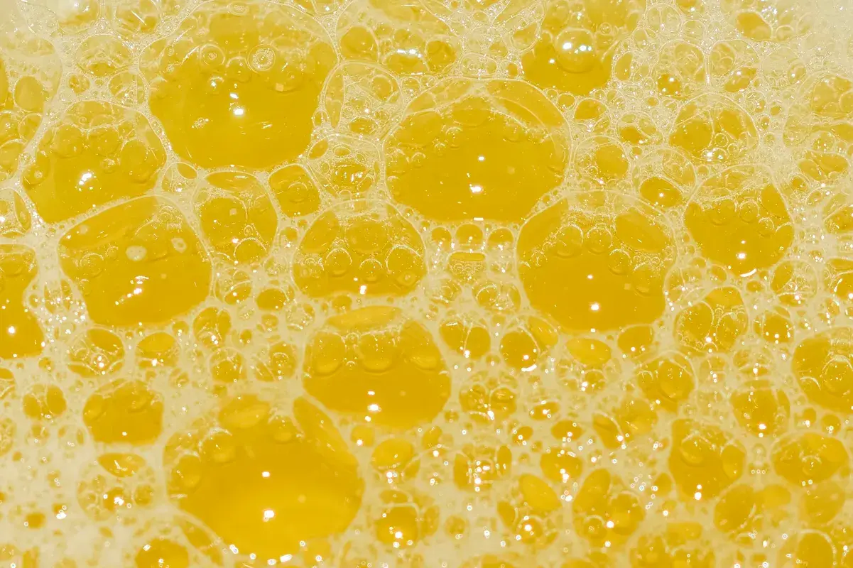 Macro background texture of yellow frothy soap bubbles