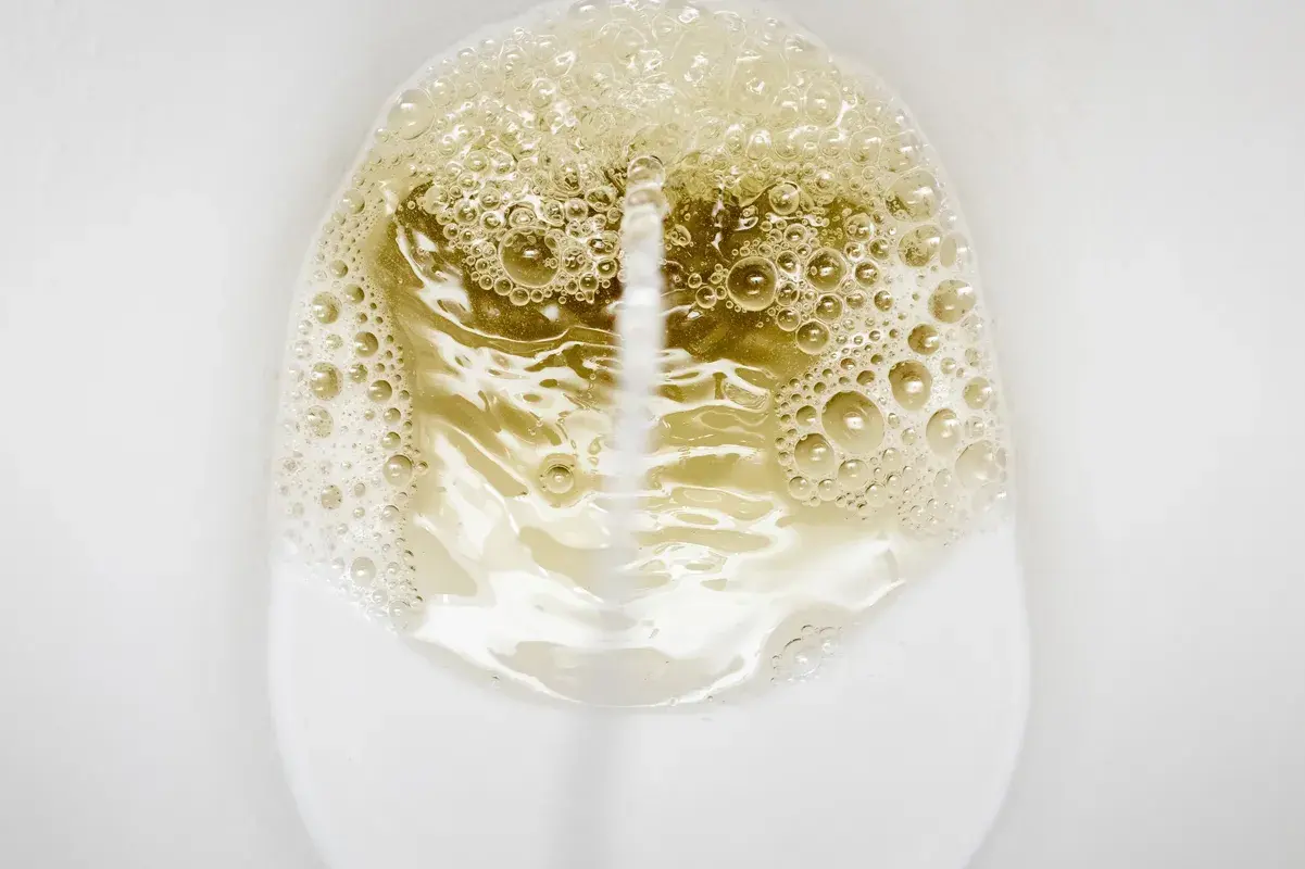 Close-up of a stream creating foamy bubbles in a toilet