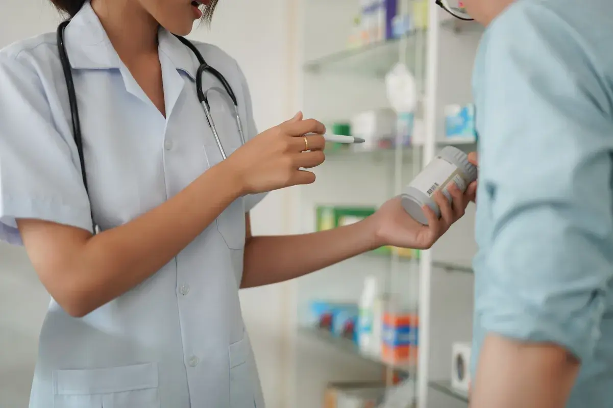 Pharmacist holding immunosuppressant medication pills and bottle