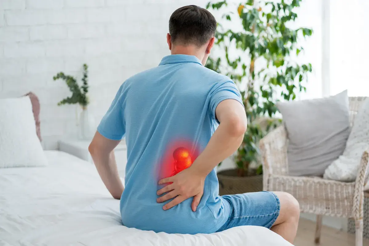 Person experiencing back pain associated with kidney problems