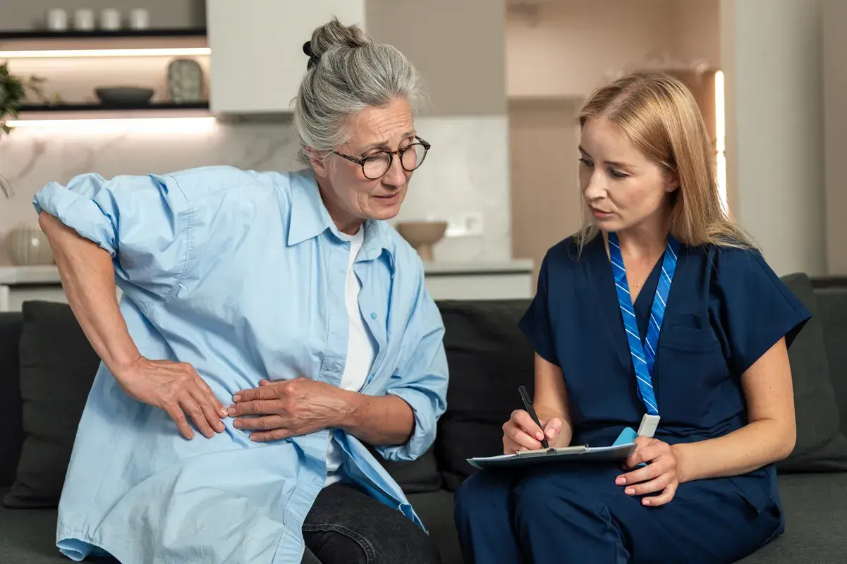 Elderly patient describing kidney pain to a nurse