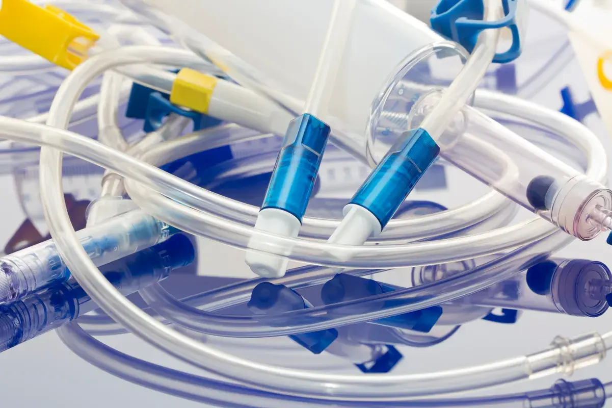 Various clinical tubing components on a reflective surface.