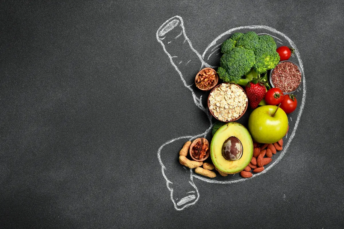 Chalk outline of a stomach filled with fresh vegetables and grains