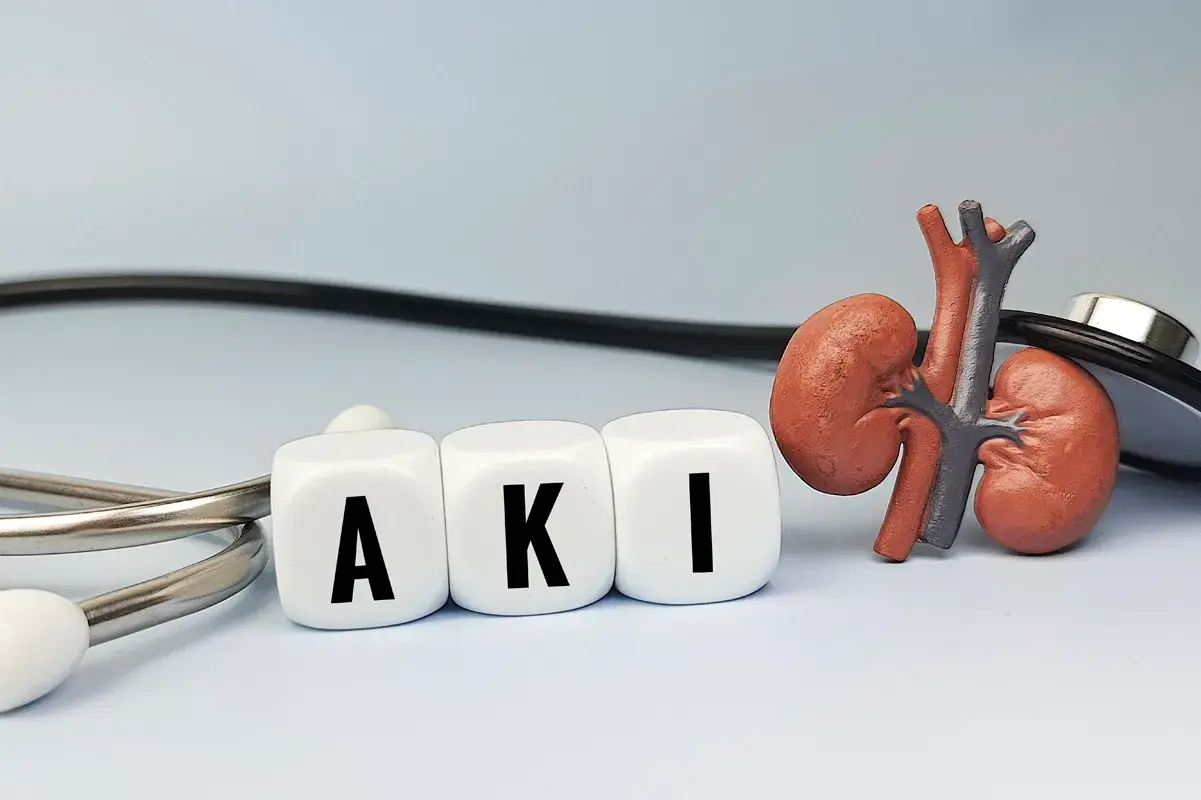A stethoscope, kidney model, and blocks spelling out "AKI"